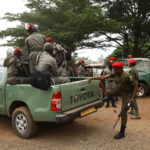 Gendarmerie officers climb a patrol vehicle ahead of an operation in Muyuka.