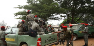 Gendarmerie officers climb a patrol vehicle ahead of an operation in Muyuka.
