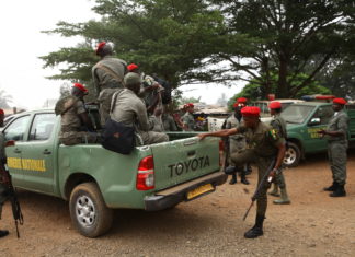 Gendarmerie officers climb a patrol vehicle ahead of an operation in Muyuka.