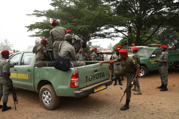 Gendarmerie officers climb a patrol vehicle ahead of an operation in Muyuka.