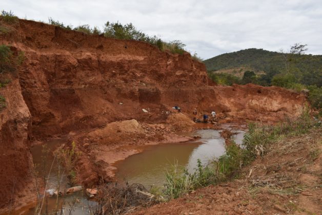 Illegal gold miners at work along a riverbed in Zimbabwe